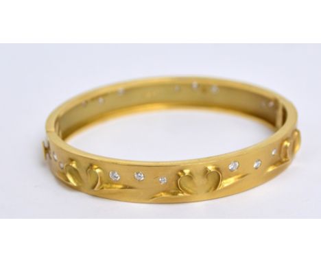 BOODLE & DUNTHORNE; an 18ct yellow gold and diamond set hinged snap bangle with moulded stylised heart decoration, fully hall