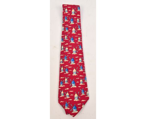 HERMES; an Hermes vintage silk tie in whimsical windmill in the sky pattern with blue windmills against a maroon ground, in a