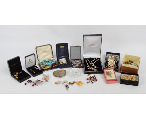 A quantity of costume jewellery  including various brooches, a hallmarked silver snap bangle with bright cut foliate decorati