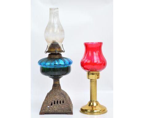 A Victorian oil lamp with blue glass reservoir above square domed cast iron floral decorated base, height 46cm including funn