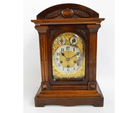 A c.1900 German walnut cased eight day mantel clock with arched case and silvered chapter ring set with Arabic numerals benea