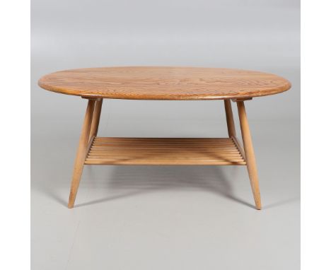 A large elm and beech coffee table with an oval top, with a spindle shelf below for storage. Model No 454. 99cms by 82cms, 44