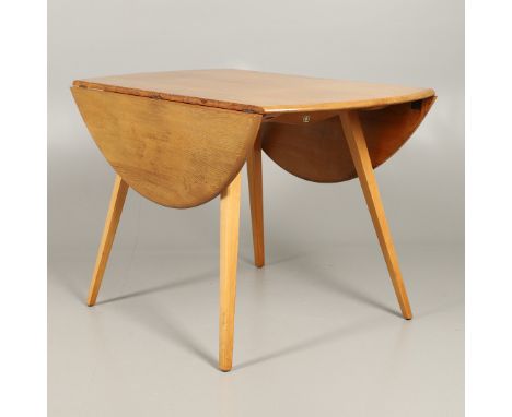 A light elm drop flap circular dining table, supported on splayed beech legs. With an Ercol sticker on one end, 71cms high, 1