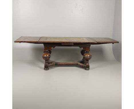 the multiple plank top with draw leaf ends over a narrow decorative frieze, and heavily turned bulbous legs joined by a Y-sha