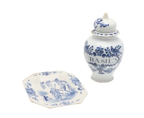 An interesting octagonal shaped delft plaque or dish, painted with an Oriental figure amongst flowering trees, and flowers ar