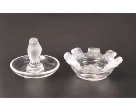 Lalique France pin dish and ashtray, decorated with frosted glass figural bird and ring of Putti respectively. Height of tall