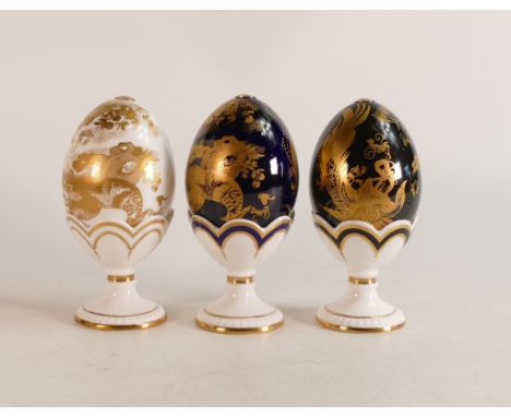 Set of three Royal Crown Derby Aves Faberge Eggs and stands, limited edition 60/500 in white, cobalt and black. Gold button, 