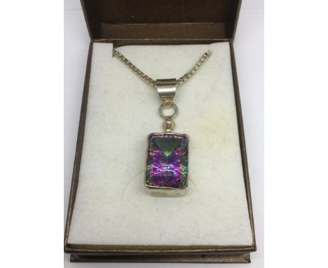 A silver cased multicoloured gemstone pendant on a heavy silver box chain.