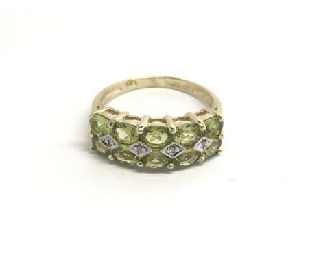 A 9carat gold ring set with green peridot and chip stone diamonds. ring size K.