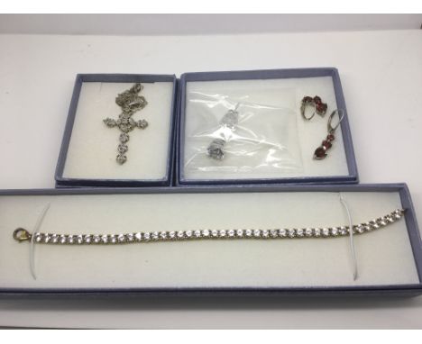 A small collection of silver jewellery set with stones comprising a necklace, crucifix on a chain and two pairs of earrings.