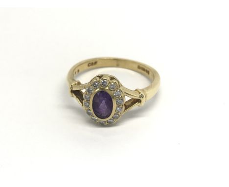 An18carat gold ring set with an oval amethyst flanked by a row of diamonds. ring size M.