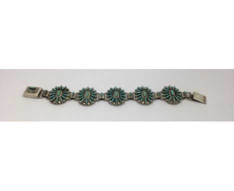 A Native American Zuni sterling silver and turquoise bracelet by Bernie Wyaco. (1 stone missing).