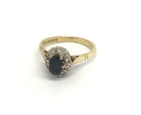 An 18carat gold ring set with a sapphire flanked by an oval of diamonds ring size K