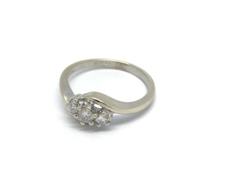 An 18 carat white gold ring set with three brilliant cut diamonds. ring size K.