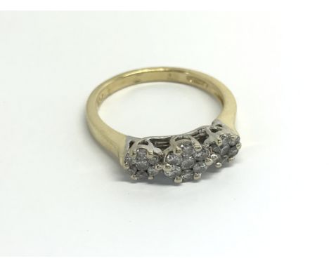 An 18carat Gold ring set with a pattern of brilliant cut diamonds in three floral round patterns. ring size N.