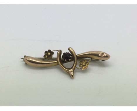 A 9ct gold brooch set with a central amethyst and decorated with a horseshoe and flowers, approx 1g.