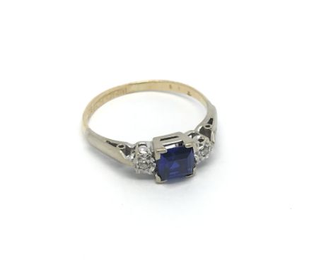 An 18ct gold and platinum ring set with a central square sapphire and a diamond to either side, approx 1.8g and approx size J