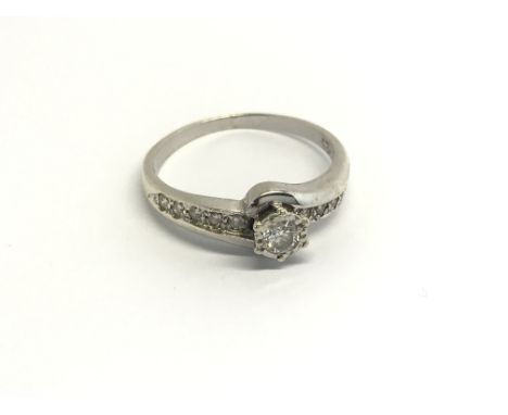 A 9carat white gold ring set with a solitaire diamond and further diamonds to the shank. Ring Size M.