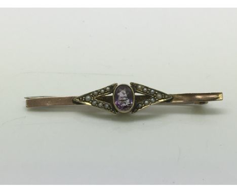 A 9ct gold brooch set with a central amethyst surrounded by seed pearls, approx 2g.