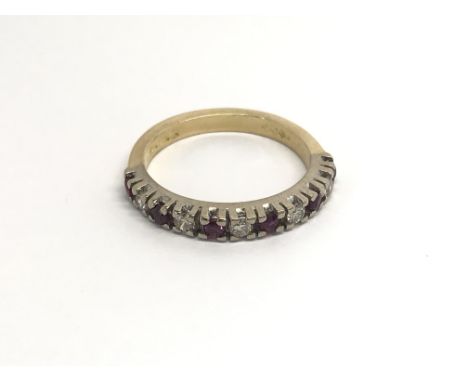 An 18 carat gold ring set with alternating RubyÕs and diamonds. ring size K.