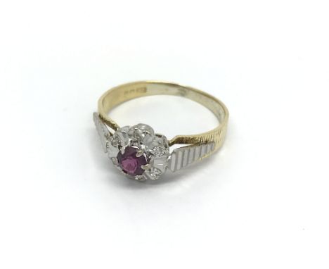 An 18 carat white and yellow gold ring set with a ruby and diamonds ring size K.