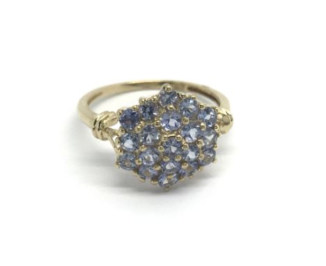 A 9carat gold ring set with a pattern of sapphire colour stones. Ring size P