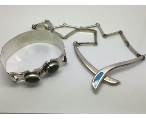 A silver necklace set with turquoise and a silver bangle.