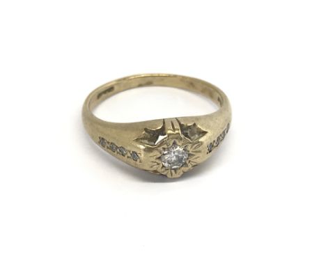 A 9carat gold ring set with a central diamond with further diamonds to the shank ring size T