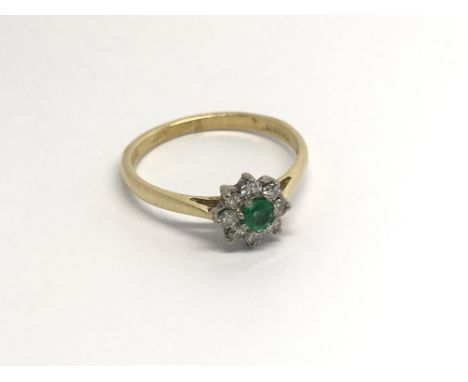 An 18carat gold ring set with a green emerald and diamonds ring size N.