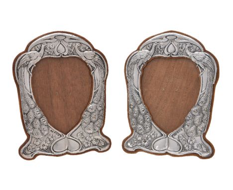 A pair of Arts and Crafts silver photograph frames by Henry Matthews, Birmingham 1901, curved rectangular, embossed with conf