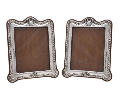 A pair of Edwardian silver photograph frames by William Neale &amp; Son, Birmingham 1909, shaped rectangular with vacant rese
