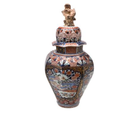 A Japanese Imari vase and cover, the domed cover with a gilt lion finial, the body decorated in underglaze blue and applied w