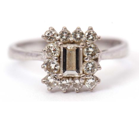 An 18ct white gold and diamond ring, set to centre with rectangular step cut diamond and surrounded by round brilliant cut di