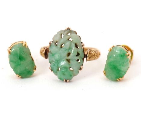 A jade ring and earrings: the ring set with a pierced oval jade cabochon, claw mounted with engraved decoration to shoulders 