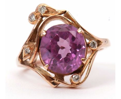 A synthetic colour change sapphire and diamond ring, the oval synthetic coloyur change sapphire in a four claw mount, surroun