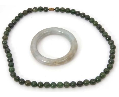 A jade bangle and nephrite necklace, the jade bangle with inner diameter 5.5cm, 85g, together with a nephrite bead necklace, 