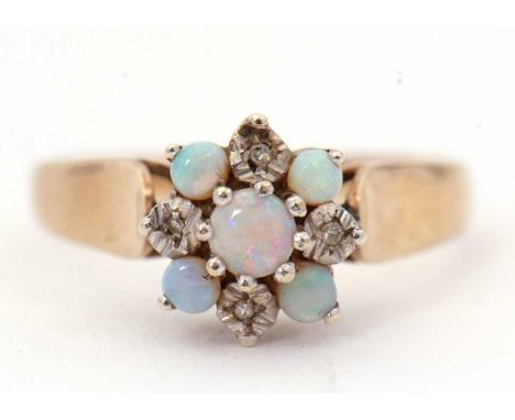 A 9ct opal and diamond ring, set with a central round opal cabochon, surrounded by alternating smaller round opal cabochons a