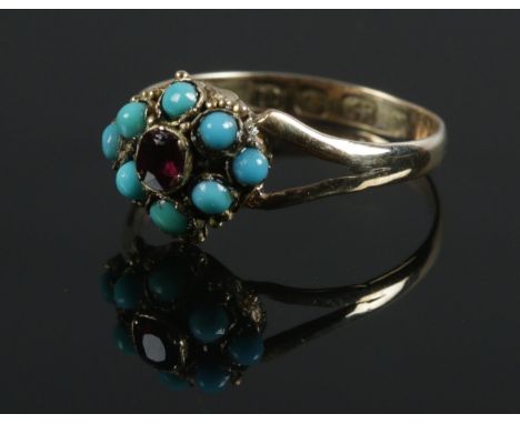 A Victorian 12ct gold turquoise and ruby cluster ring. Size I 1/2. 1.06g.  Stones appear good. The shank doesn't appear symme