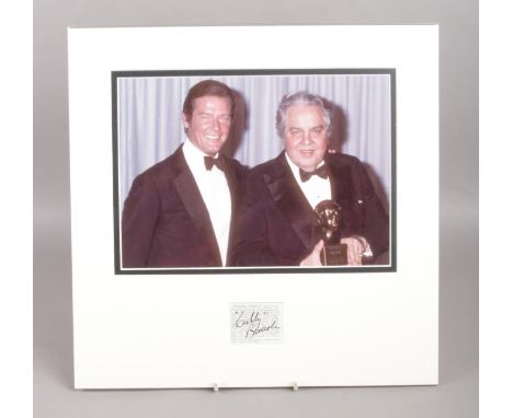 A mounted image of Cubby R. Broccoli &amp; Roger Moore with signature of Cubby Broccoli. (Executive Producer of early James B