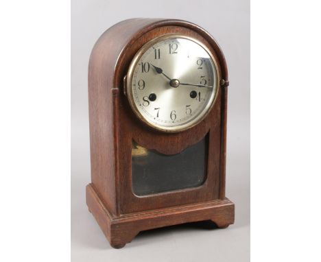 An early 20th century mahogany dome-top mantle clock. Movement stamped on the back, depicting clock face between two flags. I