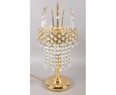 A modern gold coloured table lamp, with a chandelier droplet style shade. In working order.  