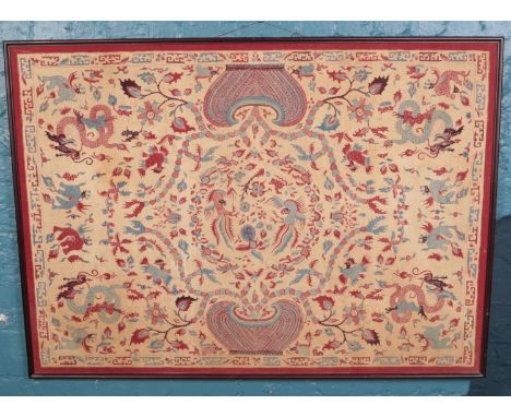 A large framed oriental print on material. Depicting dragons, etc.  Slight tear to the fabric.
