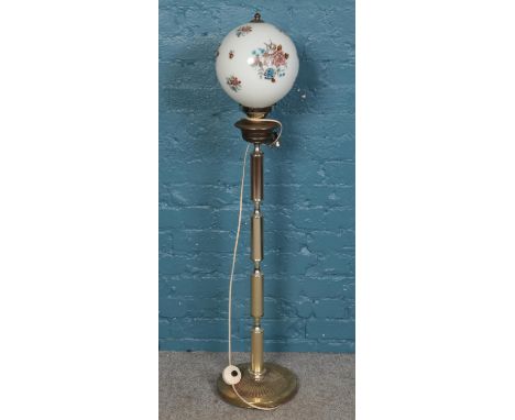 A brass standard lamp with glass dome floral decorated shade.  