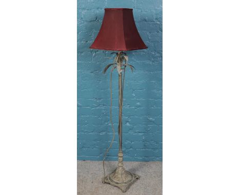 A brushed metal standard lamp with red shade.  