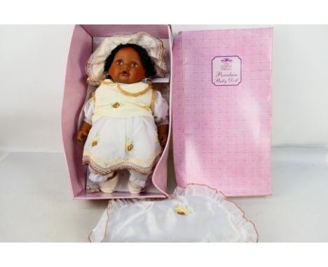 Leonardo Collection - Porcelain doll. A dark skin toned baby girl Porcelain collectors doll in her original box. She has with