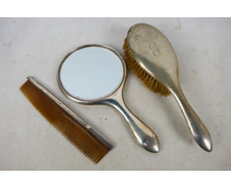 A George V silver mounted dressing table set comprising brush, hand mirror and comb, Chester assay 1924. [W]