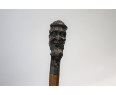 CARVED TOP WALKING STICK the top carved in the form of a gentleman with a long beard, with a metal collar and a malacca shaft