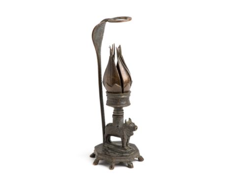 A TEMPLE LAMP IN THE FORM OF A LOTUS, NORTHERN INDIA, CIRCA 1900 the lotus burner resting on the back of a diminutive figure 