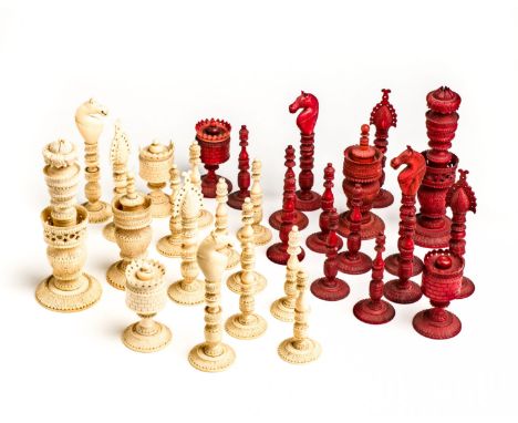 ˜AN ANGLO-INDIAN IVORY CHESS SET, BERHAMPORE, SECOND QUARTER 19TH CENTURY complete with natural and red stained pieces carved