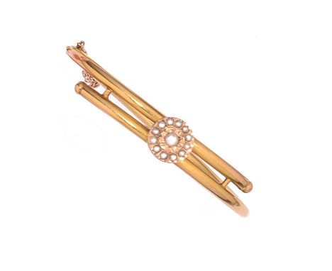 EIGHTEEN CARAT GOLD AND PEARL HINGED BANGLE, 1900s the cross over bangle with bead terminals set to the centre with a half pe